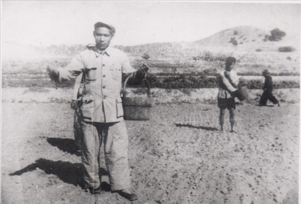 谷文昌（左）在田間與農(nóng)民一起勞動(dòng)（資料照片）。