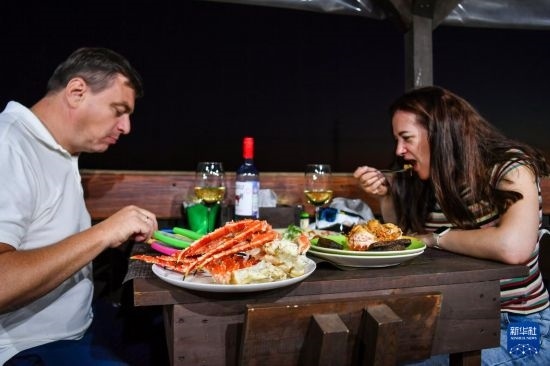 9月2日，食客們在俄羅斯符拉迪沃斯托克的一家餐館品嘗帝王蟹。新華社記者 曹陽 攝
