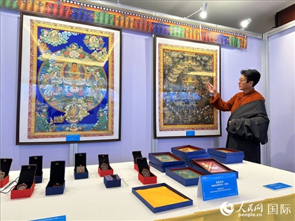 熱貢藝術(shù)國家級代表性傳承人夏吾角向嘉賓介紹作品。人民網(wǎng)記者 簡承淵攝