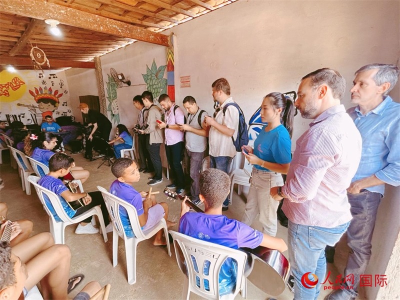  受益于中國企業(yè)的“青少年成長”項目，700多名當(dāng)?shù)厍嗌倌甑囊魳泛妥闱驂粝氩迳狭顺岚?。圖為聯(lián)合采訪團(tuán)正在采訪參加音樂培訓(xùn)的孩子們。 人民網(wǎng)記者 陳一鳴攝