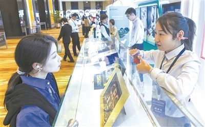 在北京麗澤商務(wù)區(qū)，工作人員（右一）介紹數(shù)字人民幣SIM卡硬錢(qián)包。新京報(bào)記者 陶冉攝