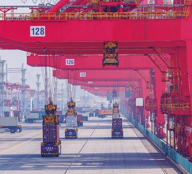 共建“一帶一路”國家在工作制度對接、技術(shù)標(biāo)準(zhǔn)協(xié)調(diào)、檢驗(yàn)結(jié)果互認(rèn)等方面強(qiáng)化合作、統(tǒng)一標(biāo)準(zhǔn)，貿(mào)易自由化便利化水平不斷提升。上海洋山港海關(guān)對接共建國家進(jìn)出口貨物相關(guān)標(biāo)準(zhǔn)，推動通關(guān)一體化方式申報，提升通關(guān)效率。圖為無人駕駛的全自動導(dǎo)引車在洋山港穿梭往來，搬運(yùn)集裝箱。王初 攝