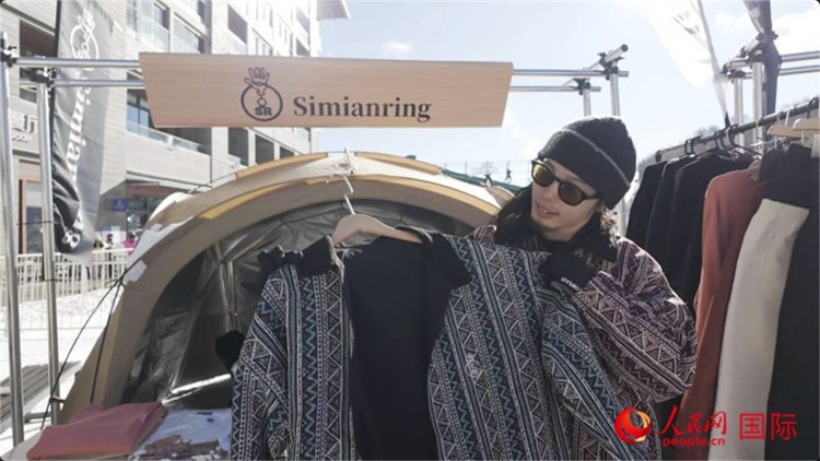 藤田周正在展示自己設(shè)計的滑雪服。人民網(wǎng)記者 袁蒙攝