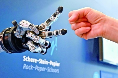 在德國漢諾威工博會(huì)上，參觀者與一款智能機(jī)器人進(jìn)行“石頭剪子布”游戲。新華社發(fā)