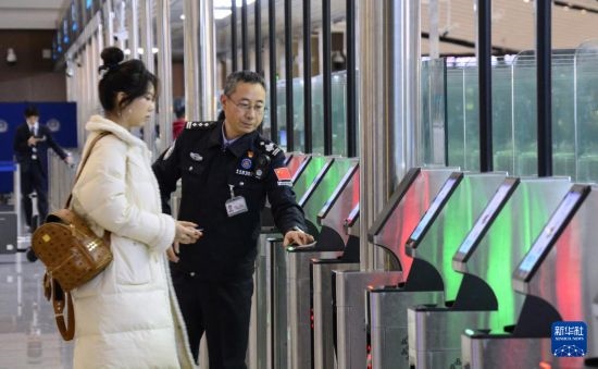 1月2日，大興機(jī)場邊檢站警察指導(dǎo)旅客使用自助出境設(shè)備。新華社記者 李欣 攝
