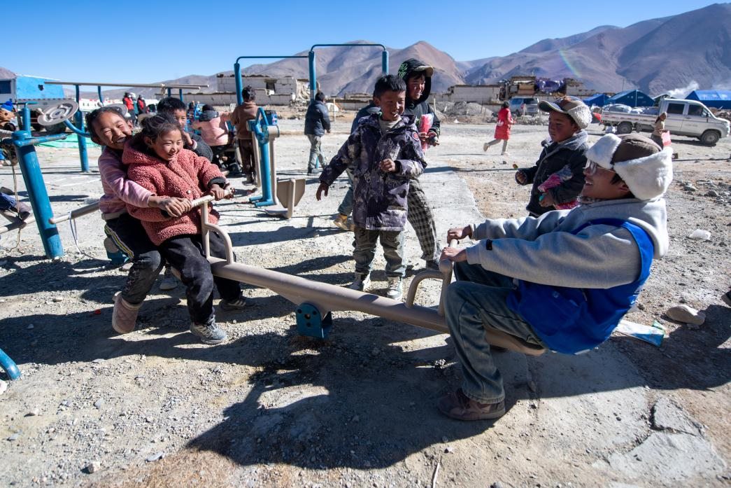 1月11日，在定日縣措果鄉(xiāng)塘仁村安置點(diǎn)，西藏星光社會(huì)工作服務(wù)中心志愿者和孩子們一起玩耍，進(jìn)行災(zāi)后心理疏導(dǎo)。人民網(wǎng)記者 翁奇羽攝