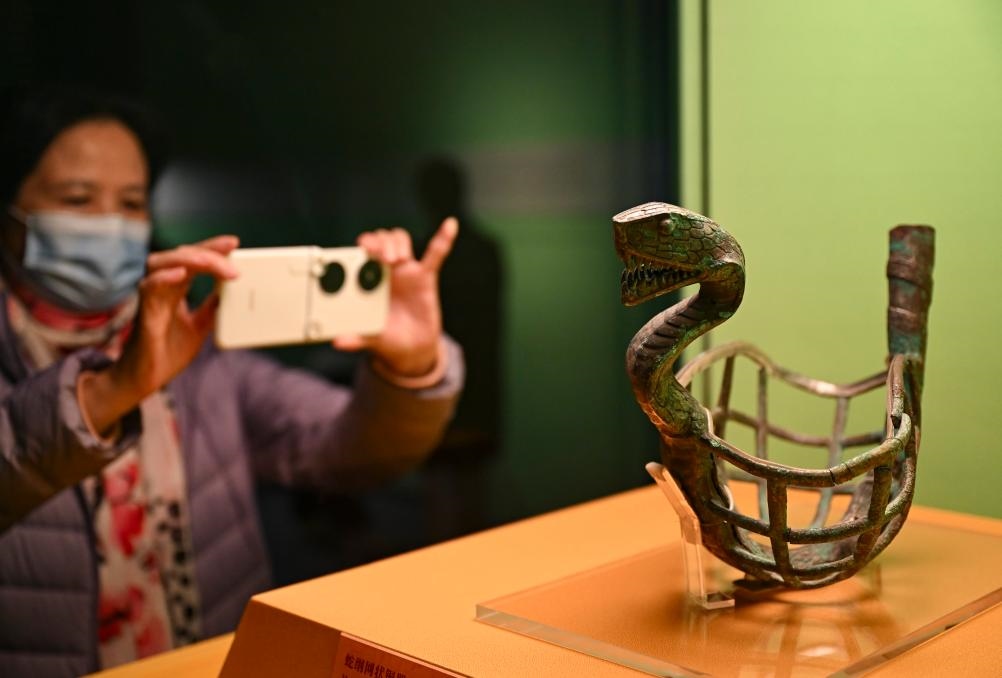 1月14日，觀眾在上海博物館蛇年迎春展拍攝展品蛇綱網(wǎng)狀銅器。新華社發(fā)（陳浩明攝）