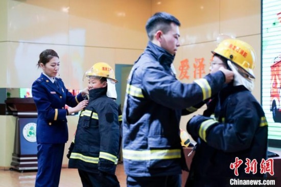 圖為學(xué)生們現(xiàn)場穿戴消防頭盔和戰(zhàn)斗服。中新社記者 趙宇航 攝
