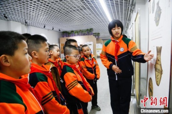 圖為學(xué)生通過展板了解出土于青海省海東市樂都區(qū)的辛店文化文物鹿紋彩陶甕。中新社記者 馬銘言 攝