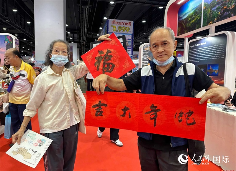 2025蛇年春節(jié)，泰國市民展示他們領(lǐng)到的華人手寫春聯(lián)。人民網(wǎng)記者 簡承淵攝