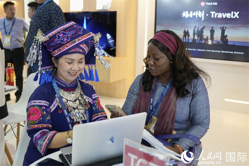 來自廣西的旅游業(yè)者同客戶交流。人民網(wǎng)塔里克·易卜拉欣攝
