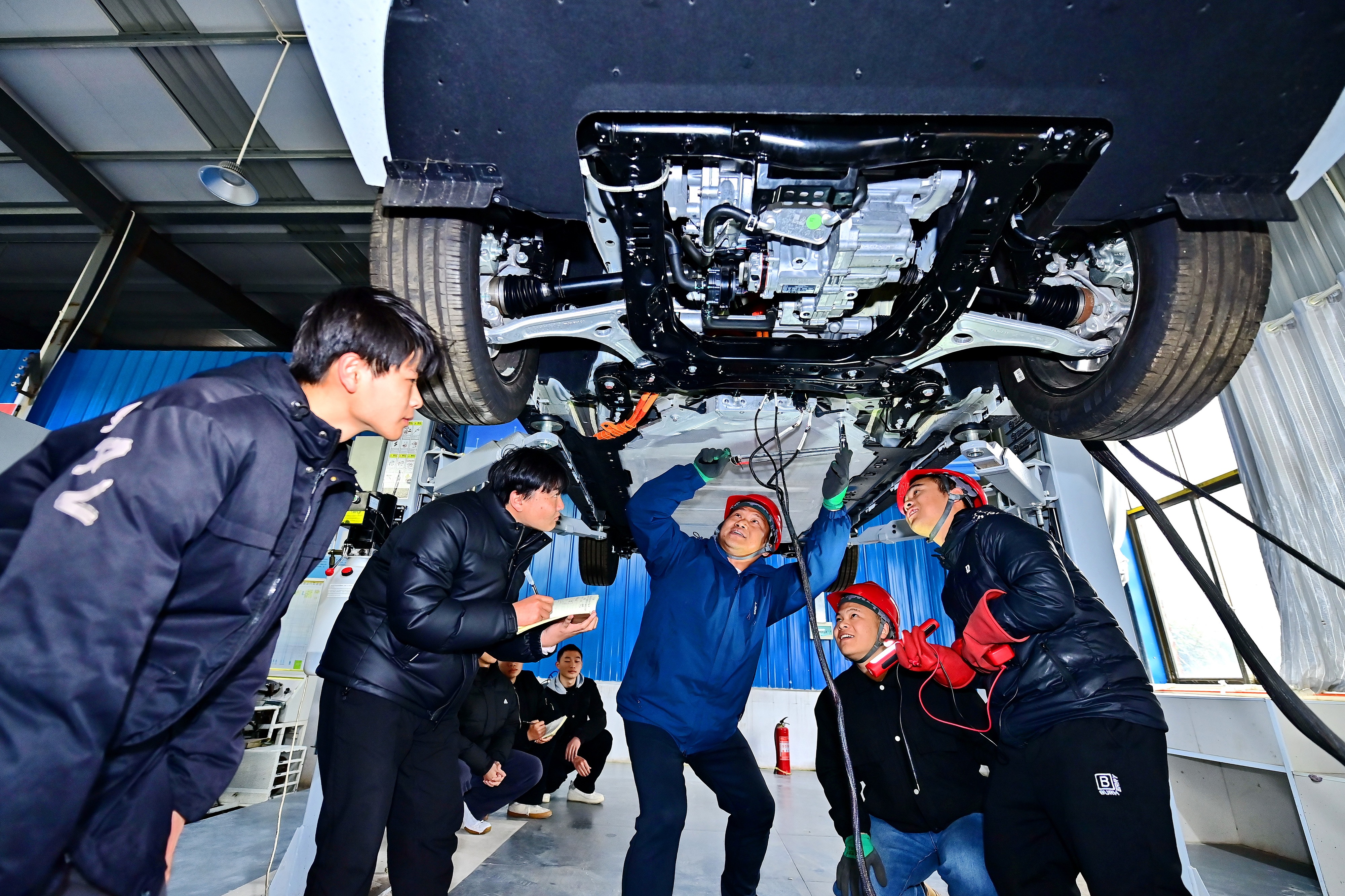 2025年2月，江西省宜春市，豐城市的一所技工學(xué)校實(shí)訓(xùn)基地內(nèi)，新能源汽車運(yùn)維專業(yè)學(xué)生在老師的指導(dǎo)下學(xué)習(xí)新能源汽車電池包檢修技術(shù)。