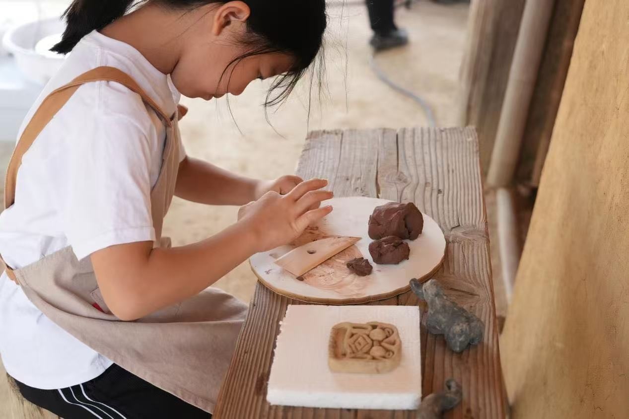 游客制作良渚特色陶藝品。良渚博物院供圖