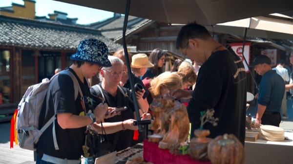 “五一”期間，游客正在烏鎮(zhèn)“水鄉(xiāng)碼頭”挑選購買文創(chuàng)產(chǎn)品。受訪者供圖