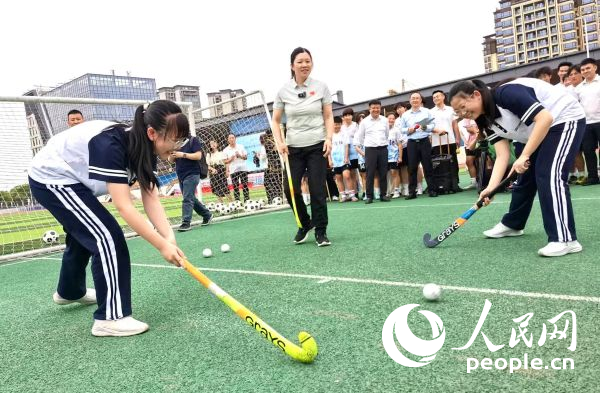 陳朝霞（中）指導(dǎo)學(xué)生體驗(yàn)曲棍球。 人民網(wǎng)記者 楊磊攝