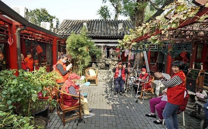 2024年10月12日，鐘樓灣胡同的老年人在社區(qū)內(nèi)的四合院養(yǎng)老驛站休閑。2017年起，北京市先后開(kāi)展了兩輪背街小巷環(huán)境整治提升行動(dòng)，完整保留了中軸線生活建筑群的歷史信息，并根據(jù)居民的生活和居住方式進(jìn)行適配化的更新和改造，極大地改善了生活環(huán)境。2023年鐘樓灣胡同被評(píng)為“北京最美街巷”。