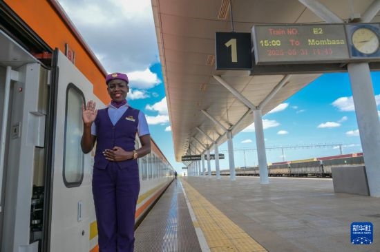 5月31日，在蒙內(nèi)鐵路內(nèi)羅畢站，一名乘務員在即將開往蒙巴薩的E2次列車旁等候乘客。新華社記者 楊光 攝