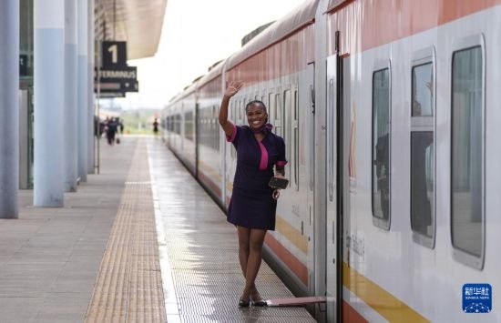 5月31日，在蒙內(nèi)鐵路內(nèi)羅畢站，一名乘務員在即將開往蒙巴薩的E2次列車旁等候乘客。新華社記者 李亞輝 攝