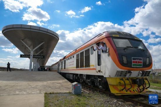 5月31日，在蒙內(nèi)鐵路內(nèi)羅畢站，機車駕駛員蔣立平（右）和博爾在即將開往蒙巴薩的E2次列車上揮手致意。新華社記者 楊光 攝